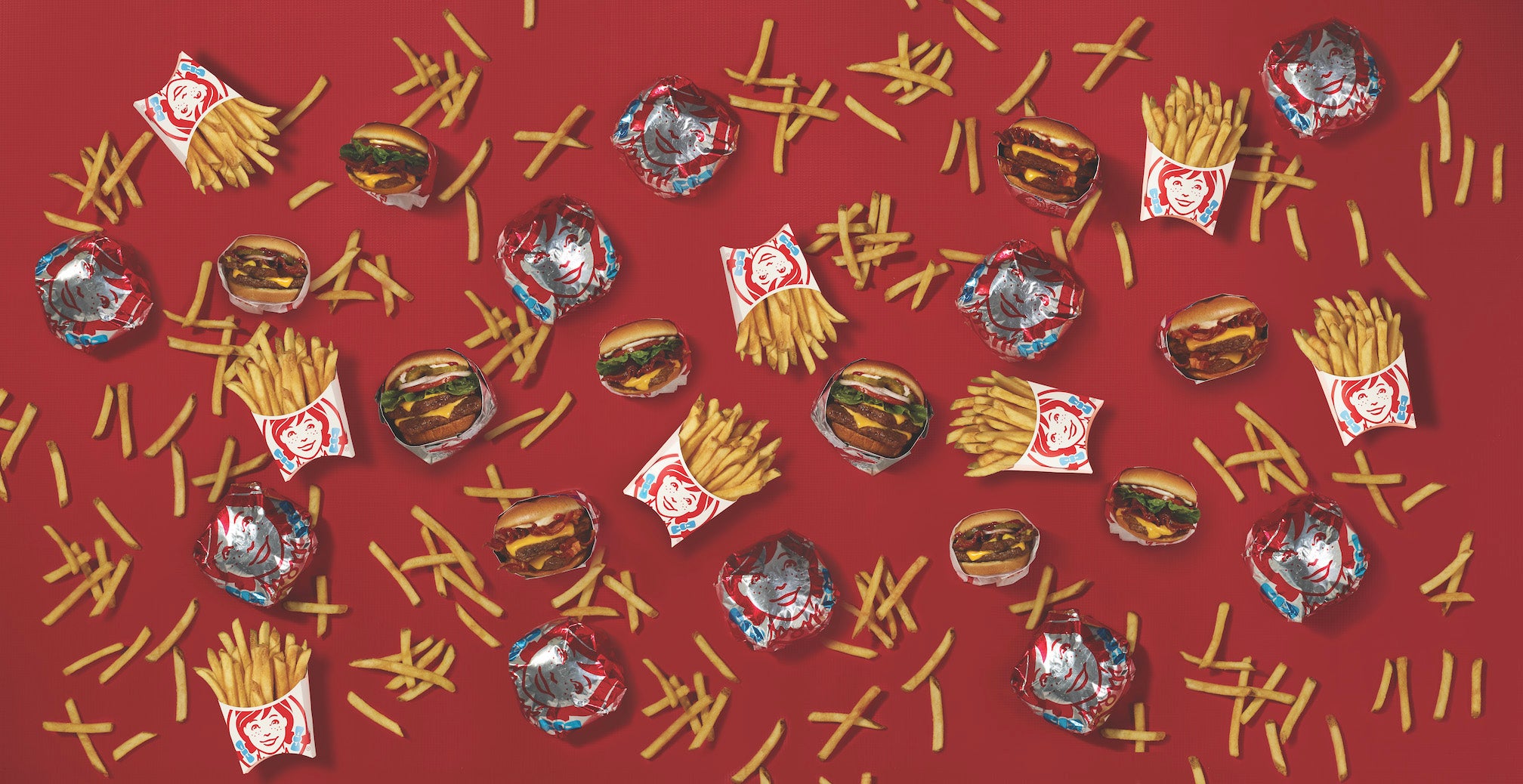 Fries, Wrapped Sandwiches on Red Background Behind Text